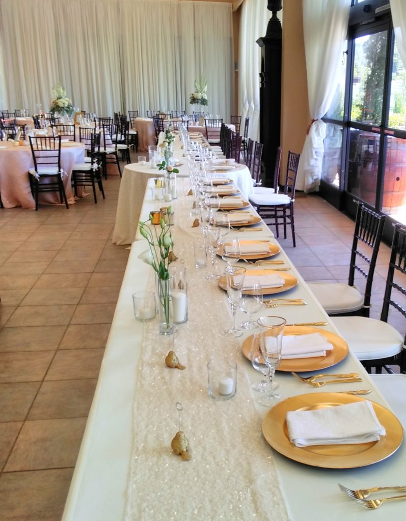 Head table with gold plates at our wedding venue