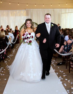 A newly-married couple walks down the aisle at the Foothills Event Center