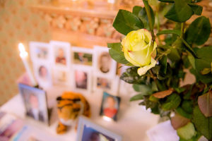 table of flowers and photos at a memorial service